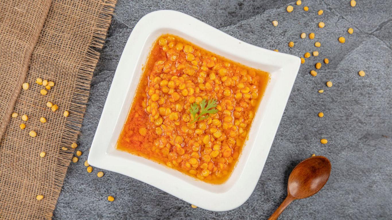 Bowl of lentil curry on stone surface