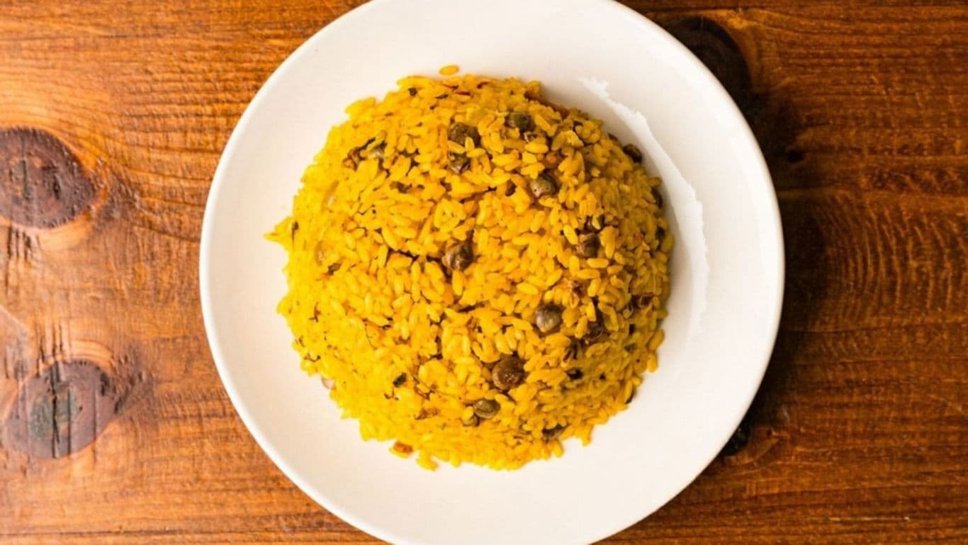 Yellow rice with beans on white plate