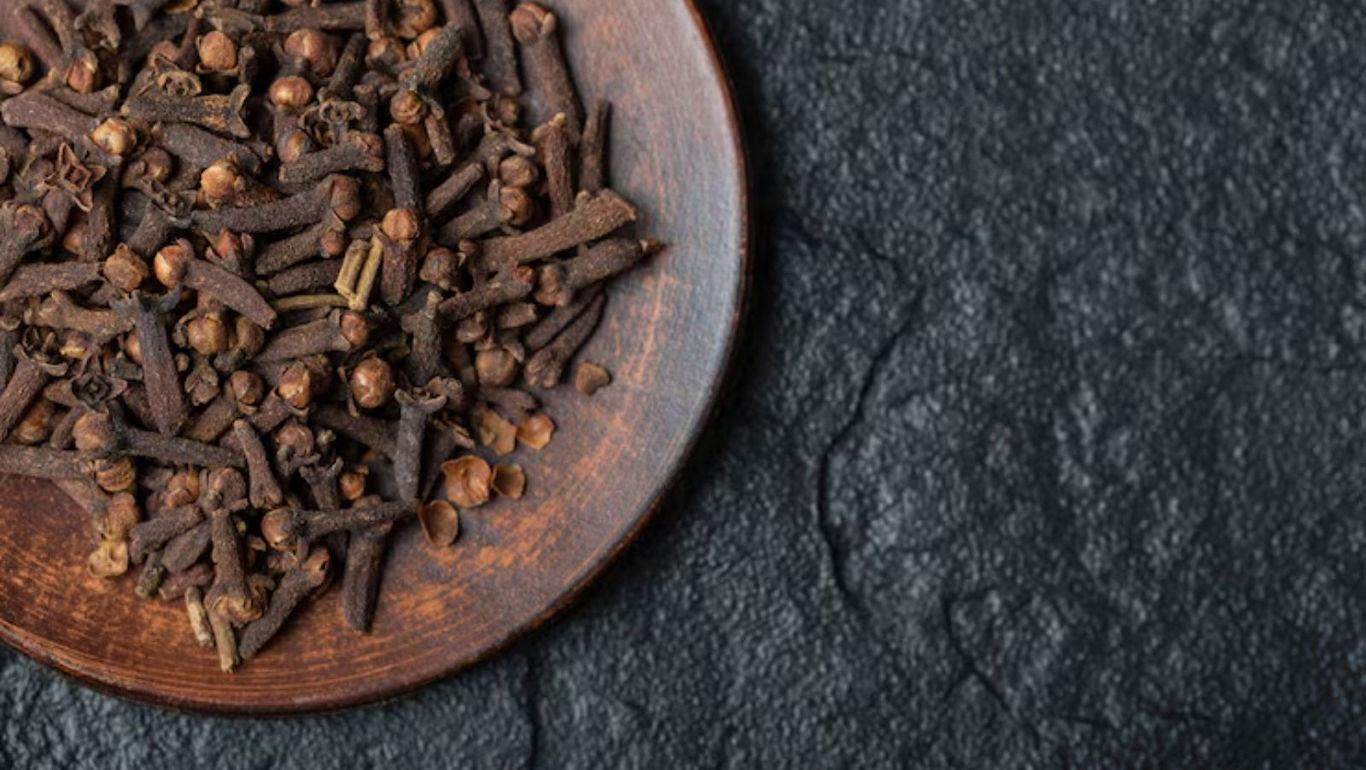 Wooden Plate of Dried Cloves on Dark Surface