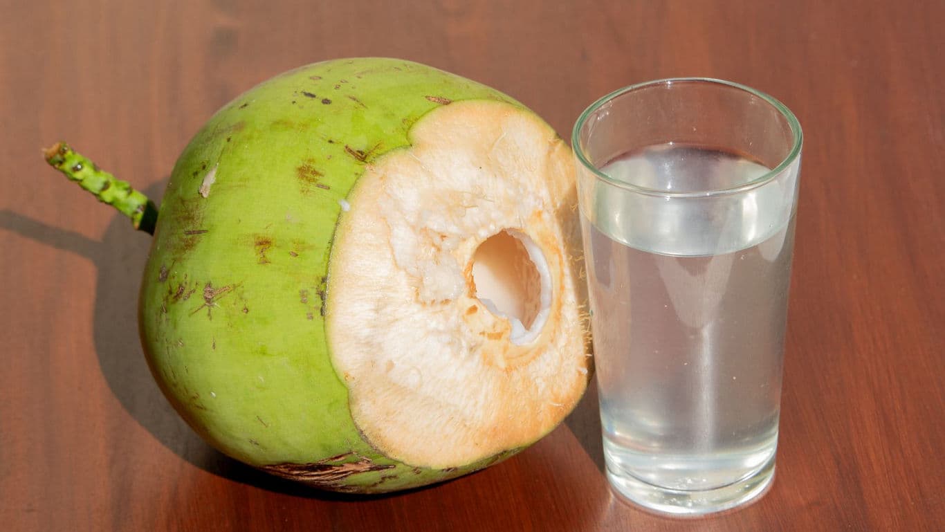 Fresh green coconut and glass of water