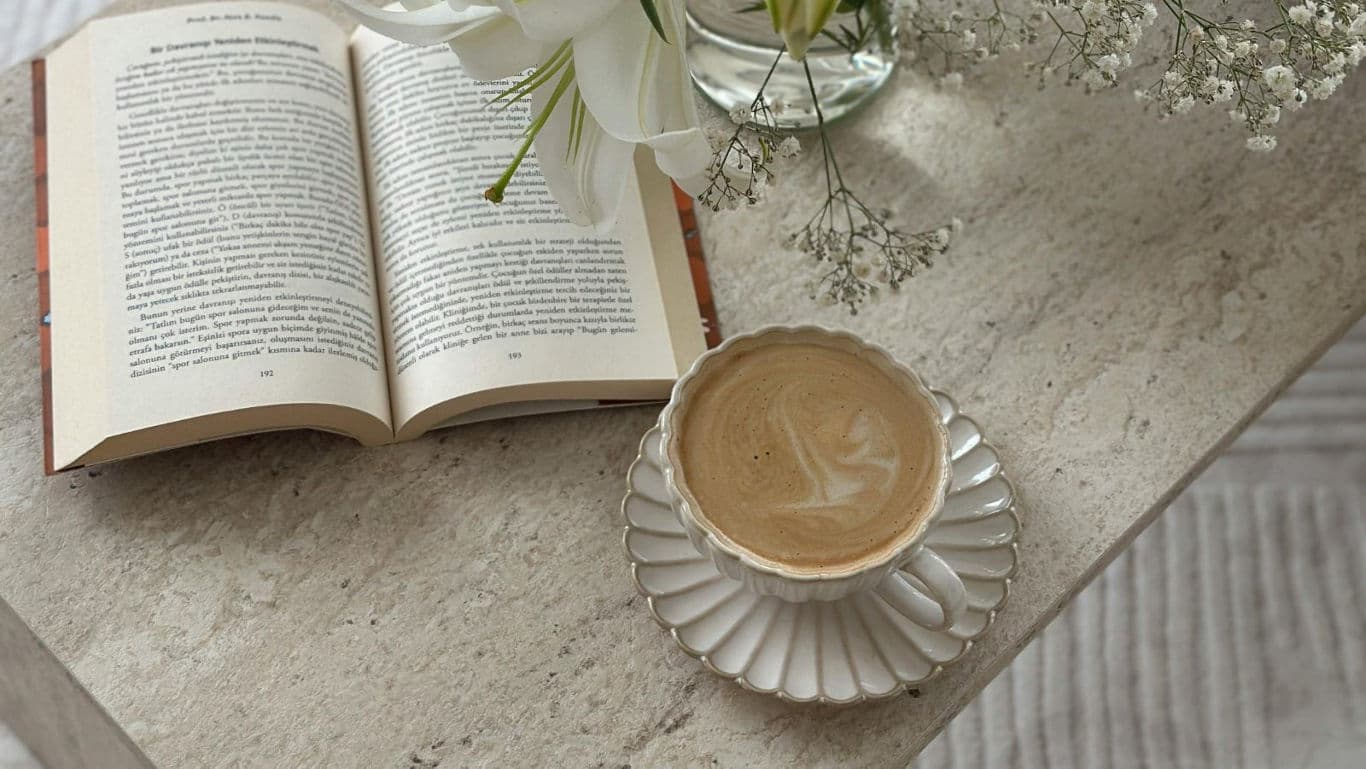 Open book with coffee on marble table