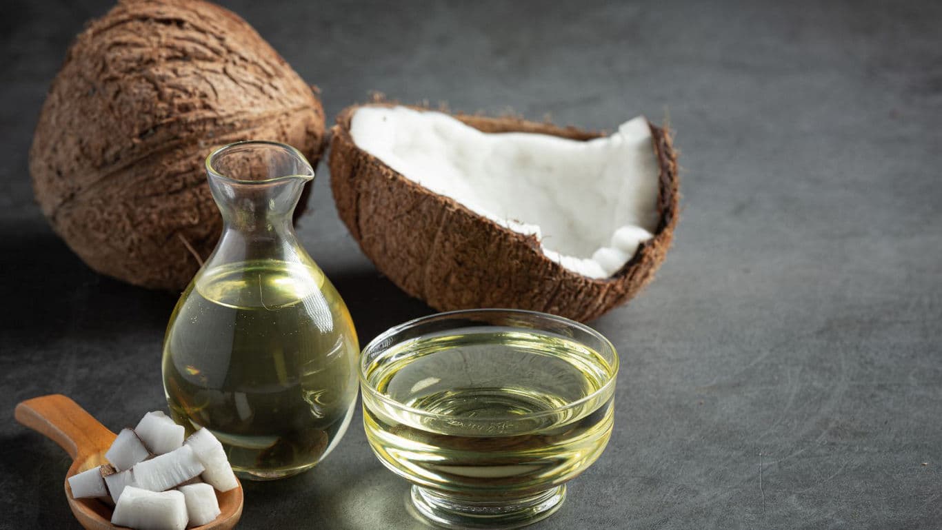 Coconut oil in glass containers with fresh coconut pieces