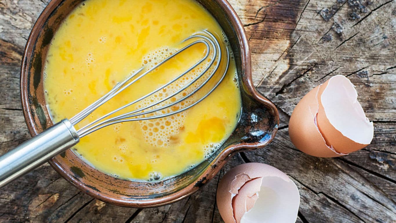 Whisked Eggs in Bowl with Broken Eggshells