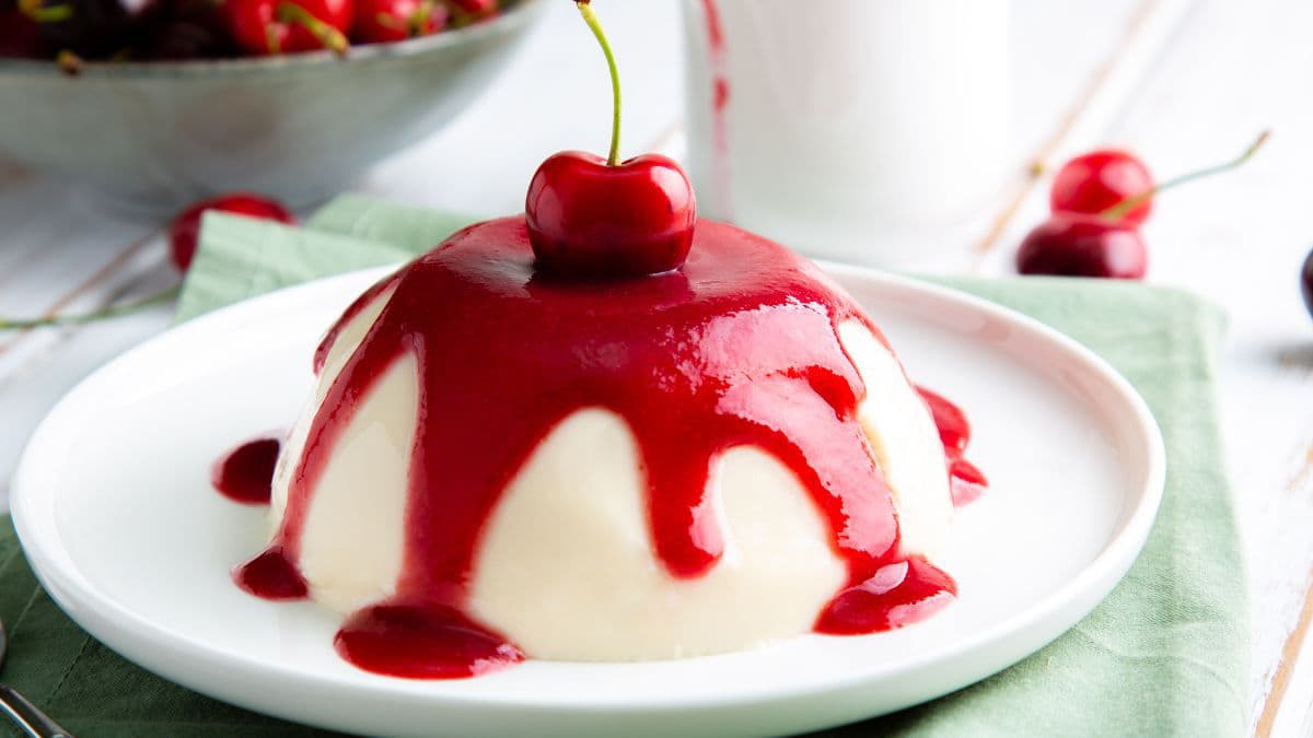 Cherry sauce dripping over pannacotta