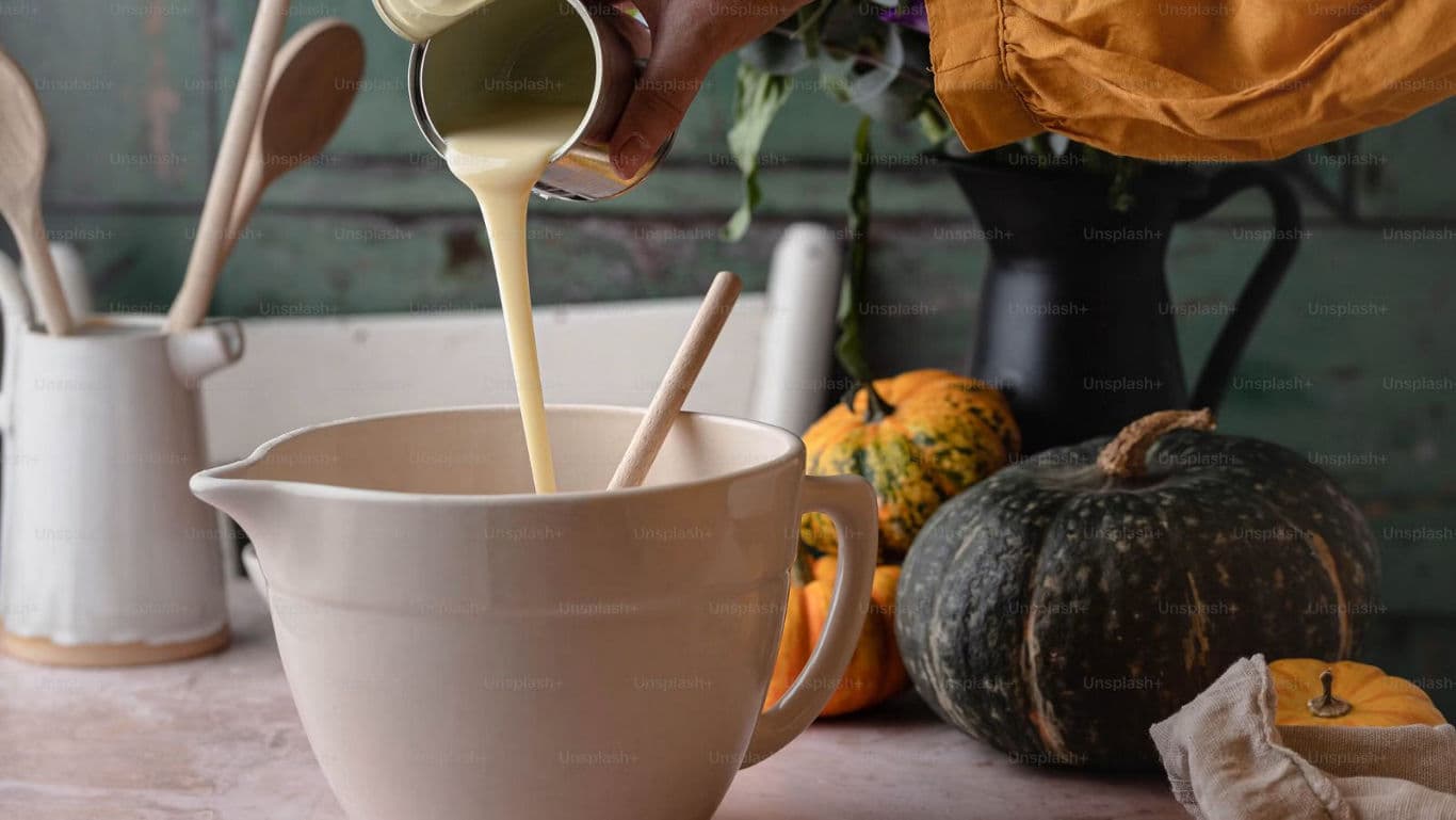 Pouring batter into mixing bowl for baking