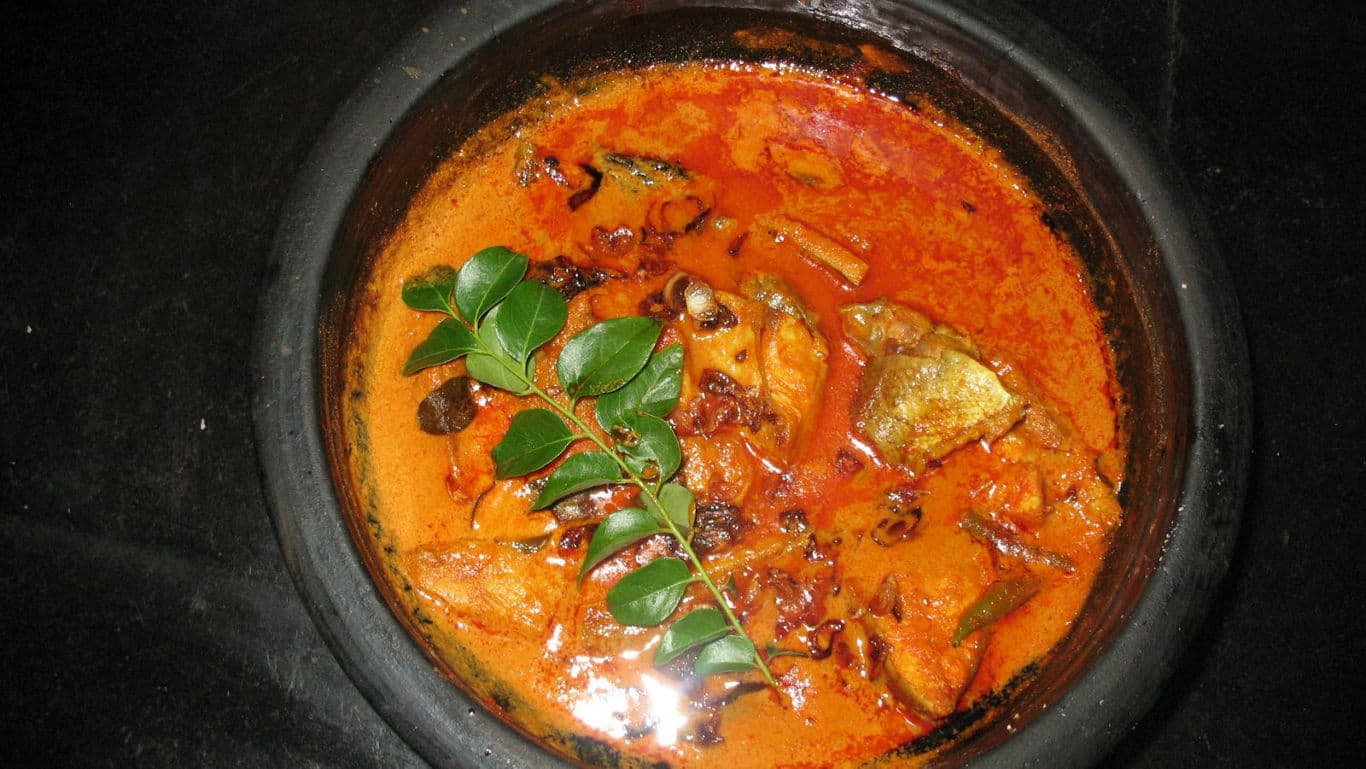 Traditional spicy fish curry in black clay pot