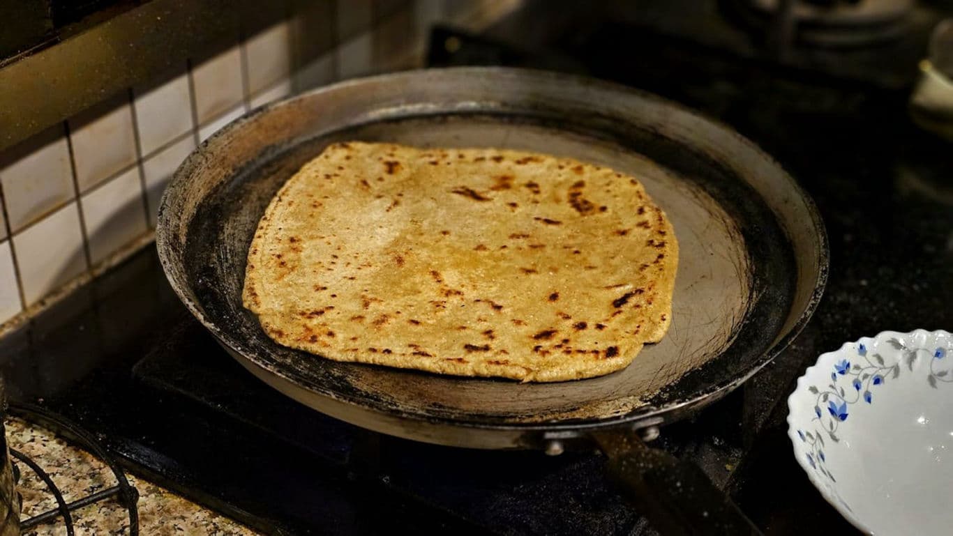 Fresh flatbread cooking on stovetop skillet