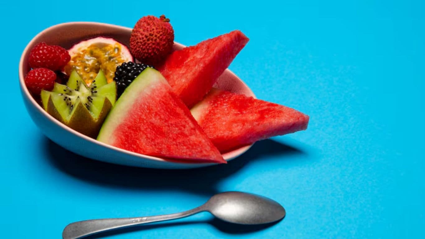 Fresh Mixed Fruit Bowl on Blue Background