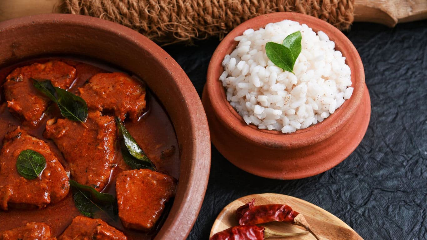 Spicy curry and steamed rice in clay pots
