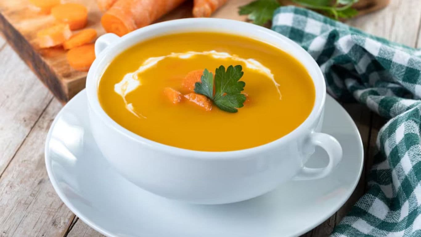 Creamy carrot soup in white bowl