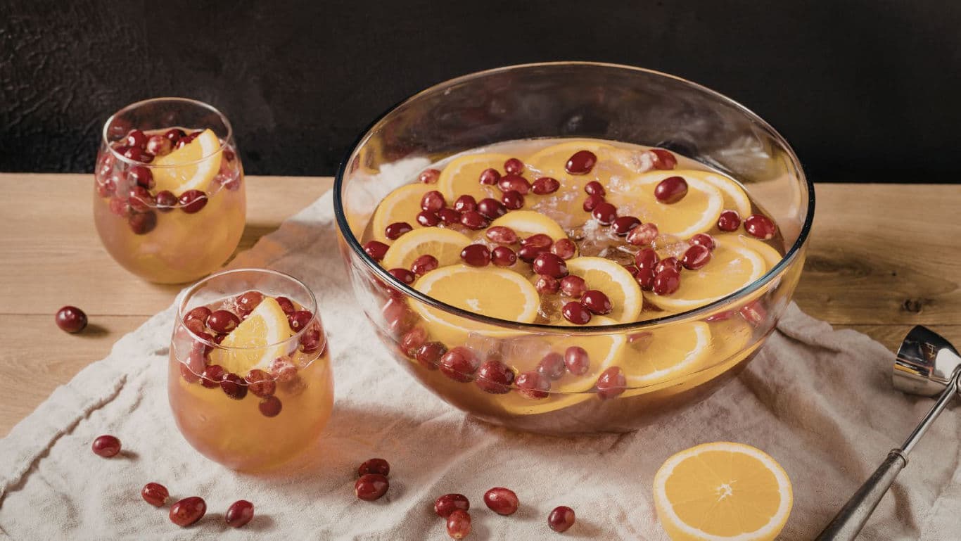 Fruit punch with orange slices and grapes in glass bowl