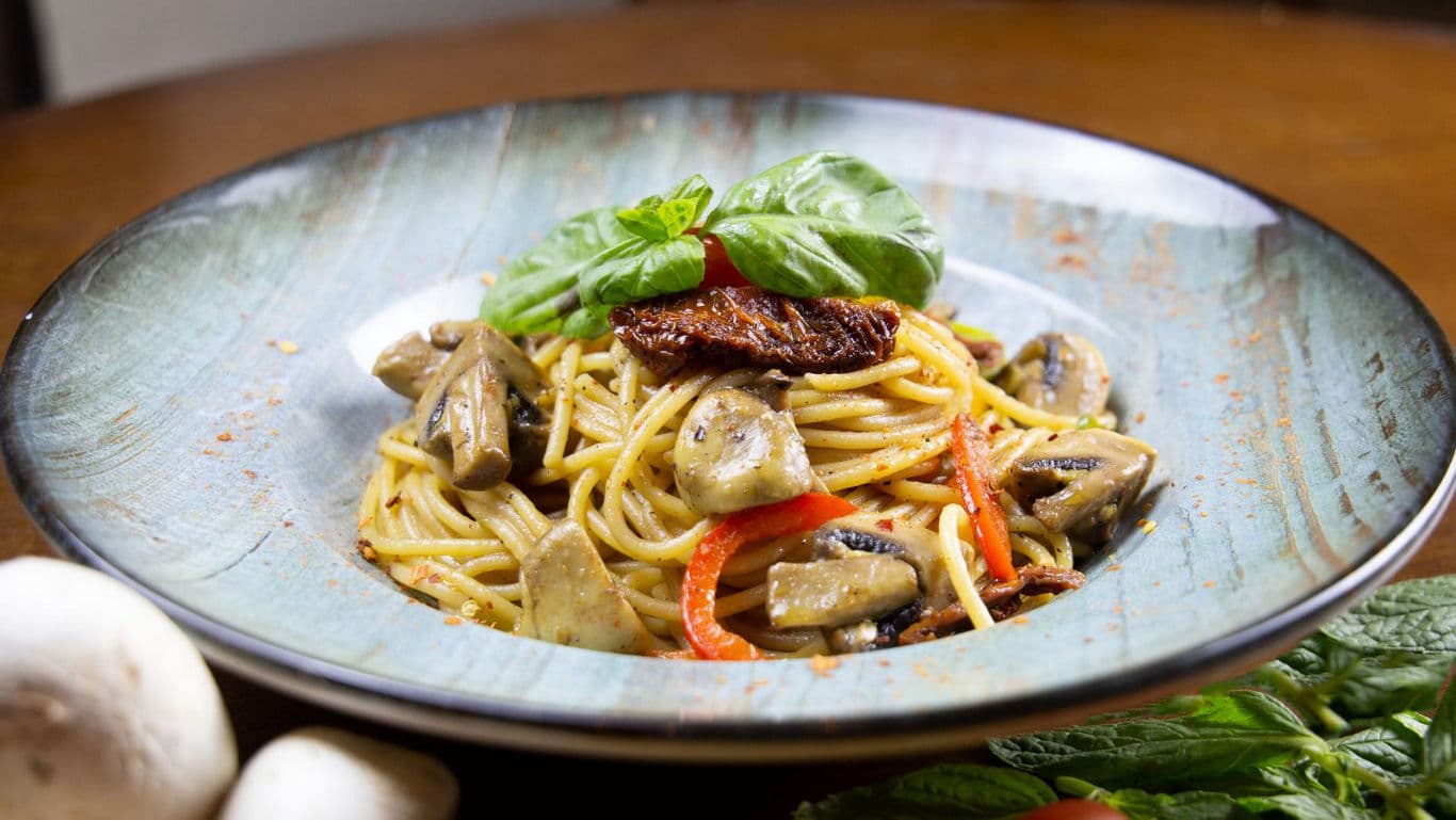 Gourmet spaghetti with mushrooms and basil garnish
