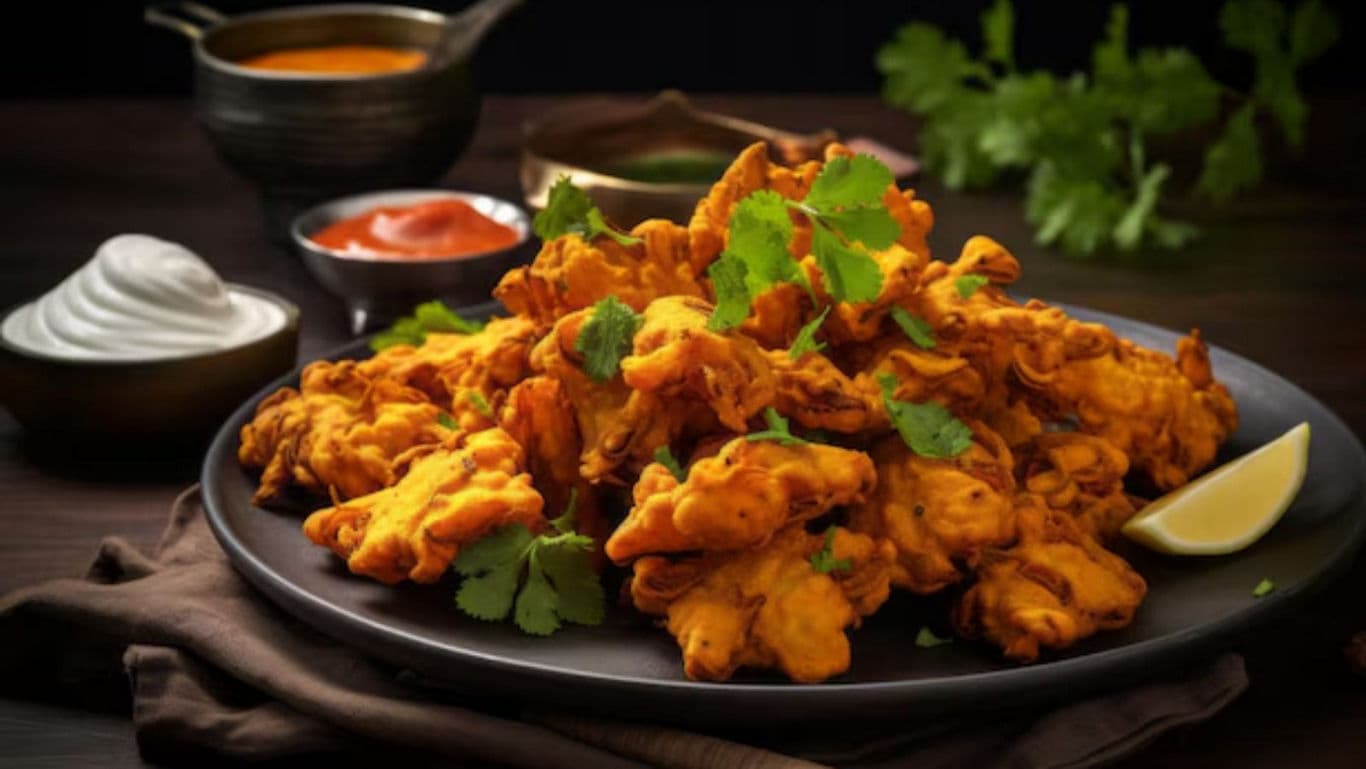 Plate of crispy vegetable pakoras with dips