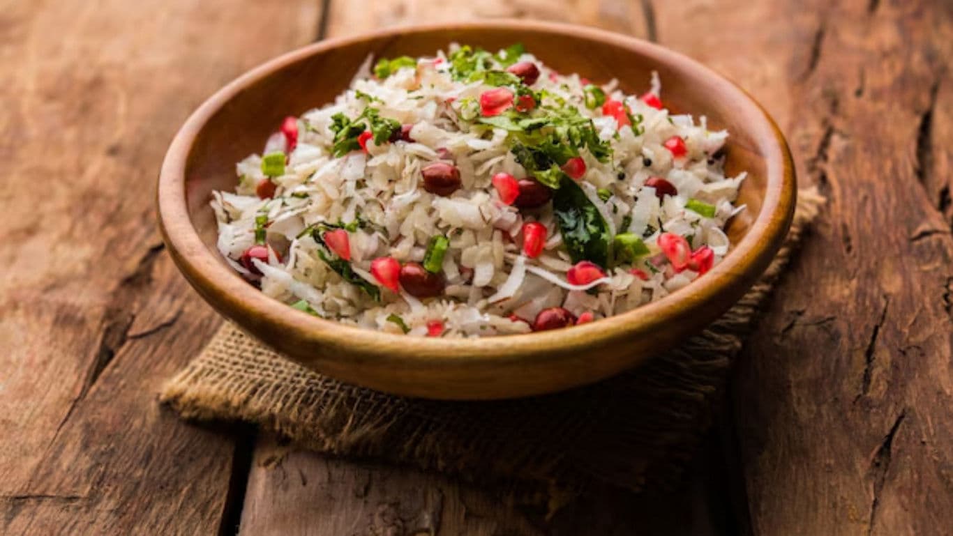 Wooden bowl of Indian poha with pomegranate seeds