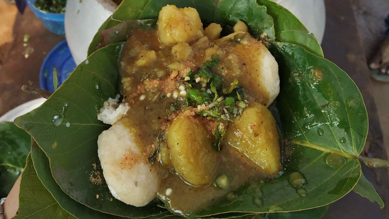 Traditional street food served on green leaf plate