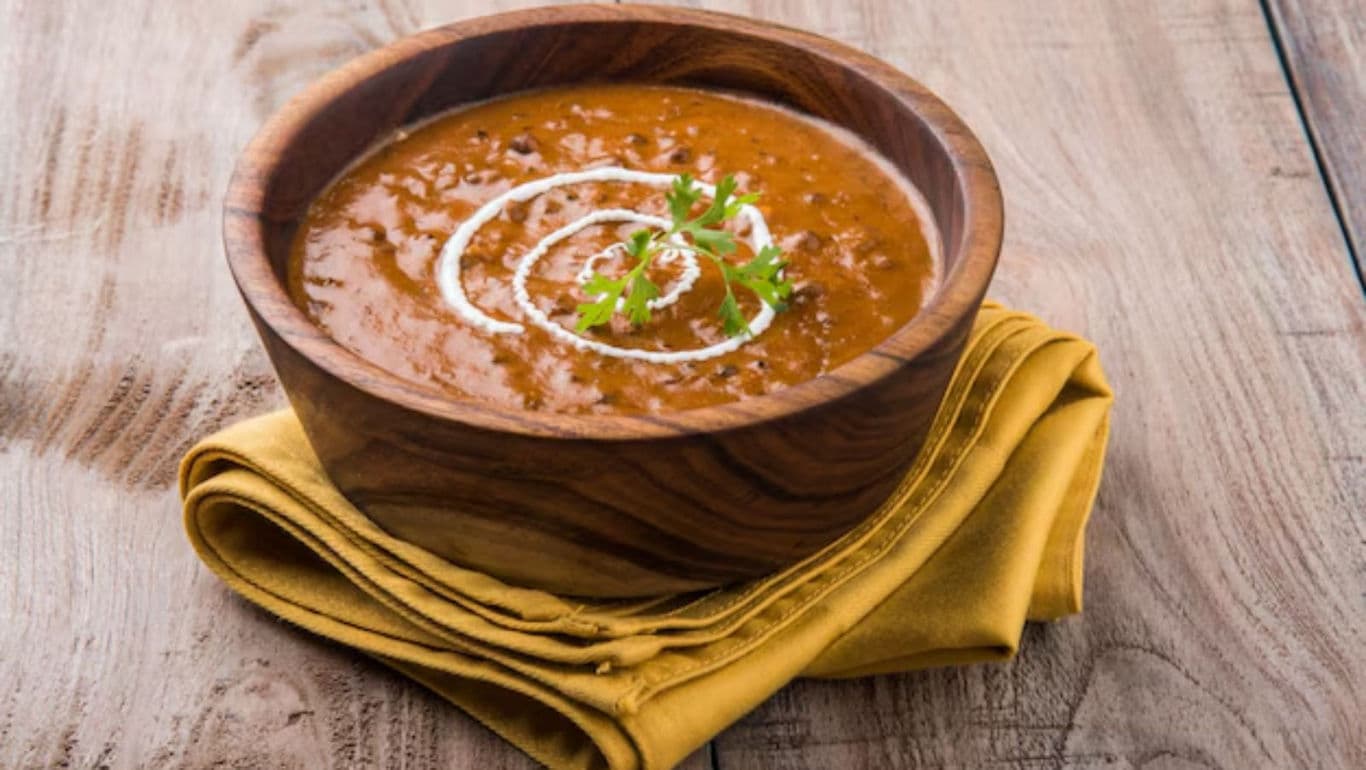 Wooden bowl of lentil soup on table