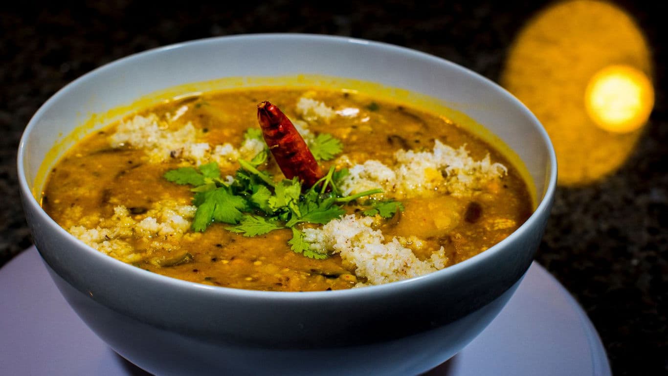 Spicy Indian lentil curry garnished with chili and herbs