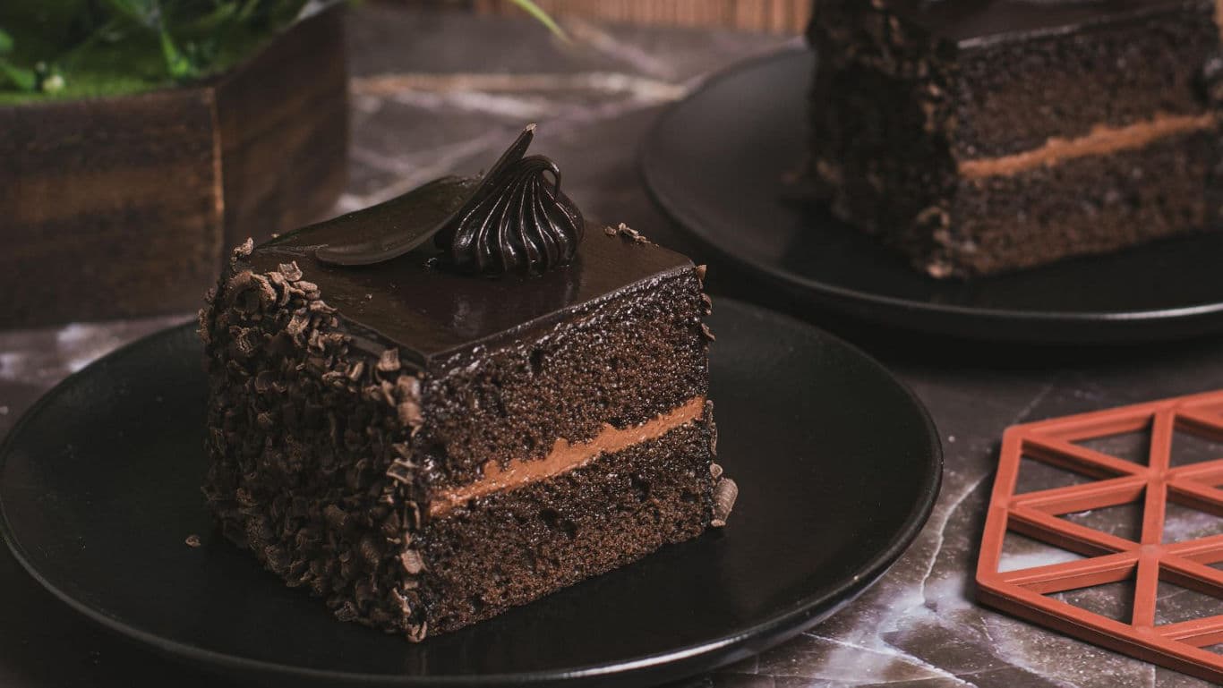 Chocolate cake slice on black ceramic plate