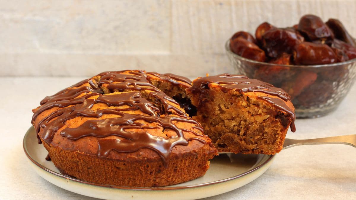 A date cake with a slice on a plate