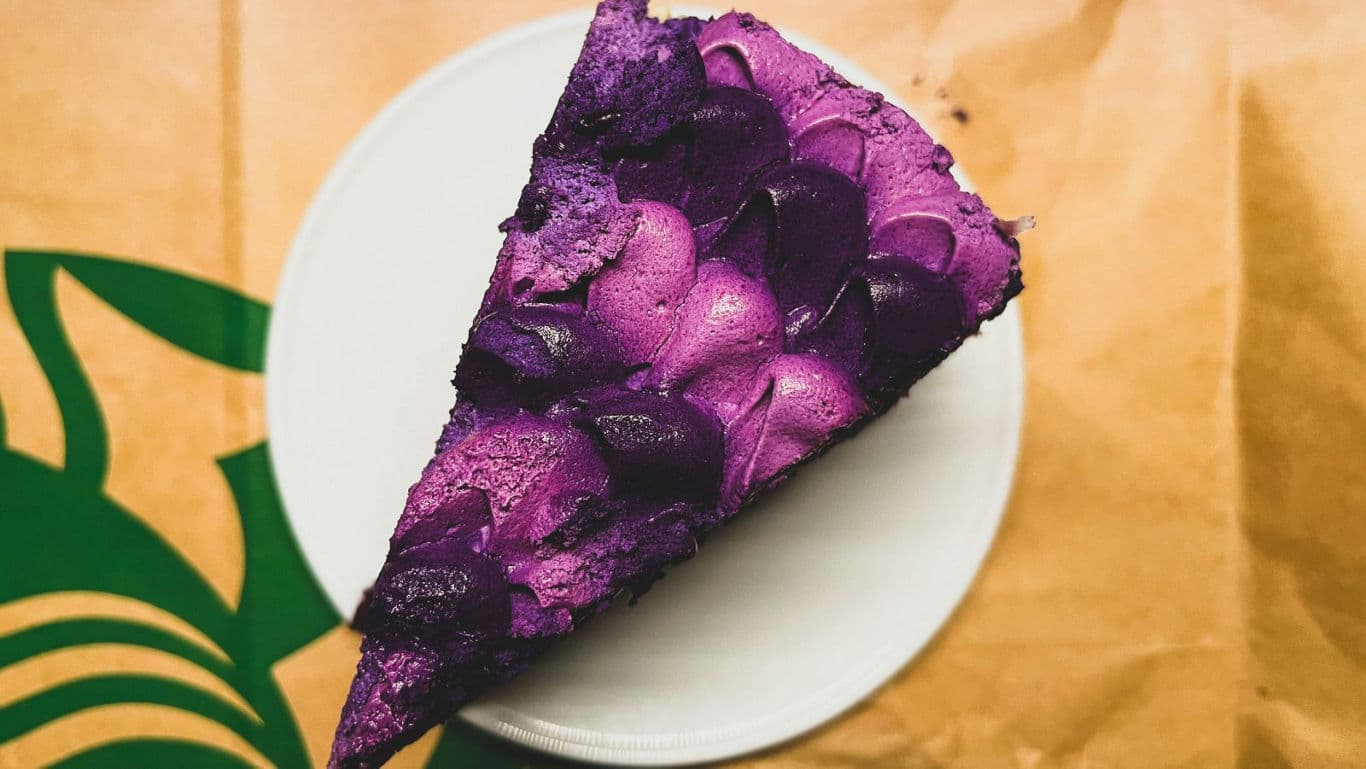 Slice of purple frosted cake on plate