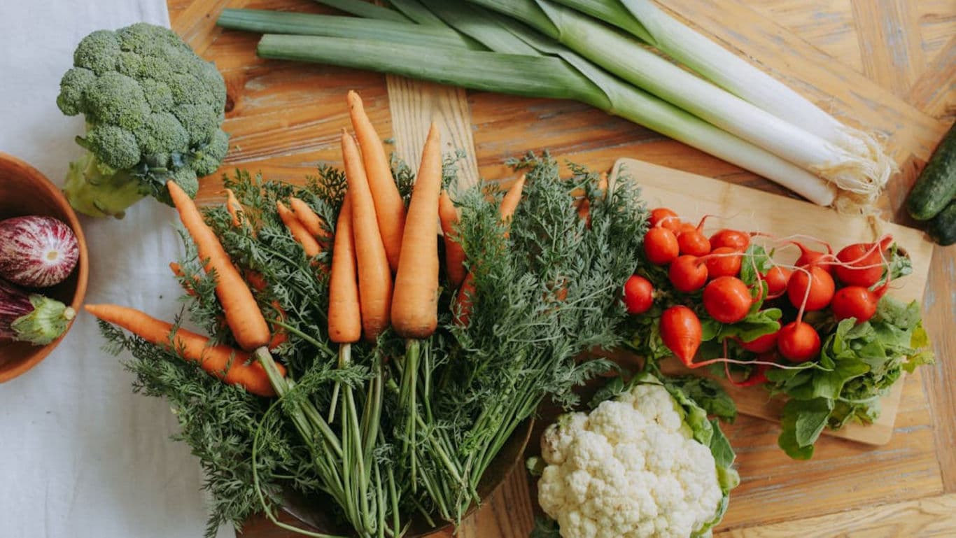 Fresh assorted vegetables on wooden kitchen table
