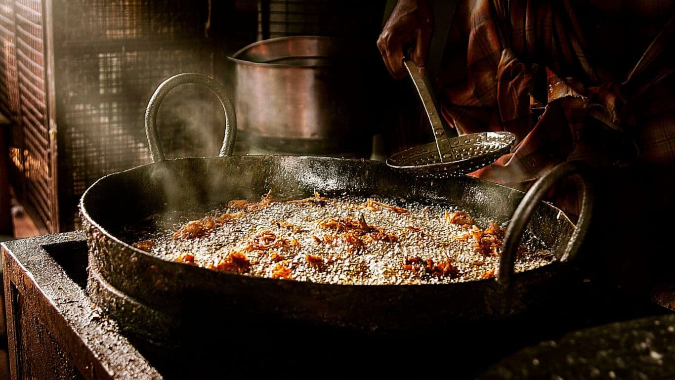 Street vendor frying food in large wok