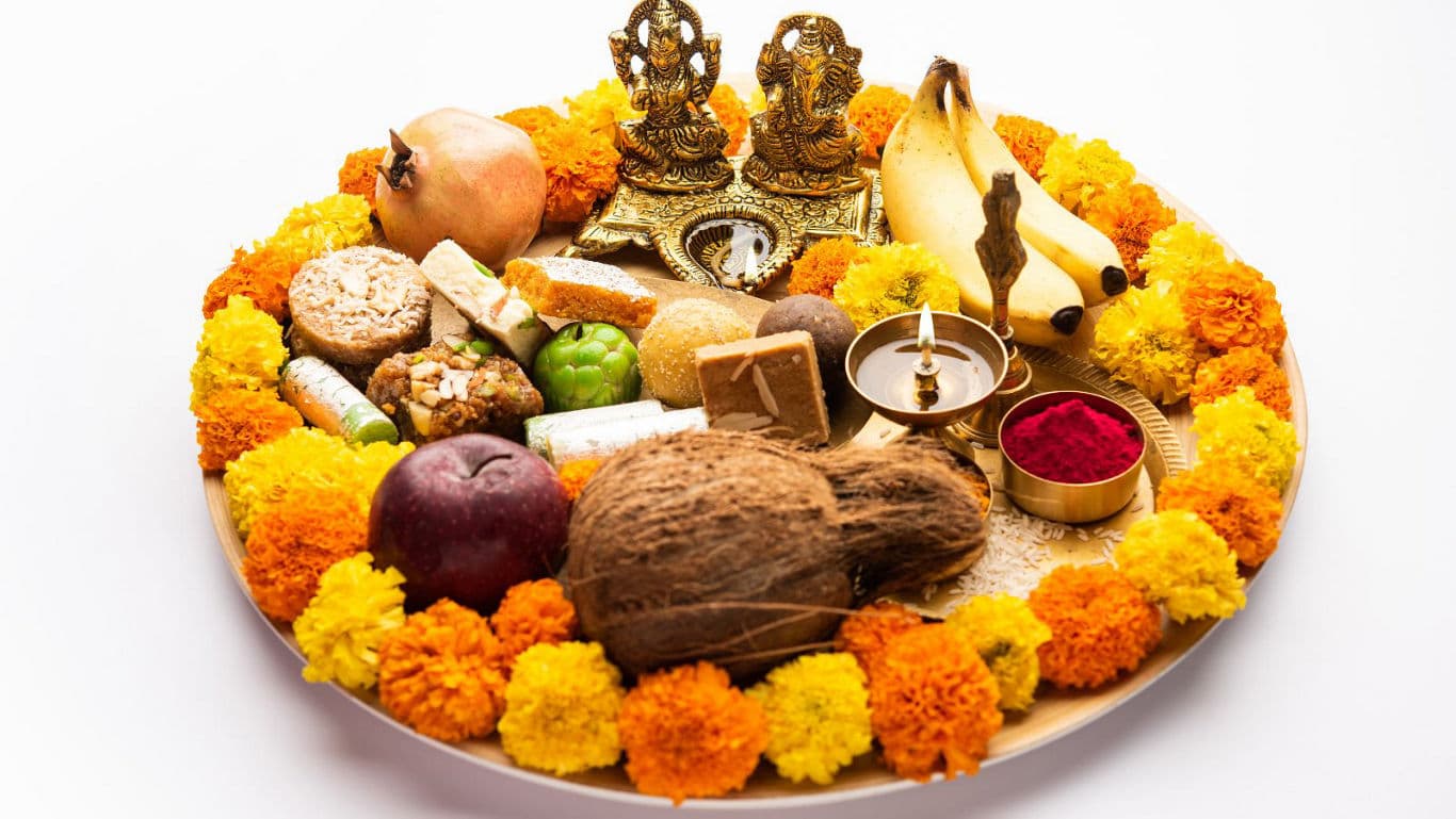A plate of Laxmi Ganesh Puja with ceremonial food and flowers - banner image