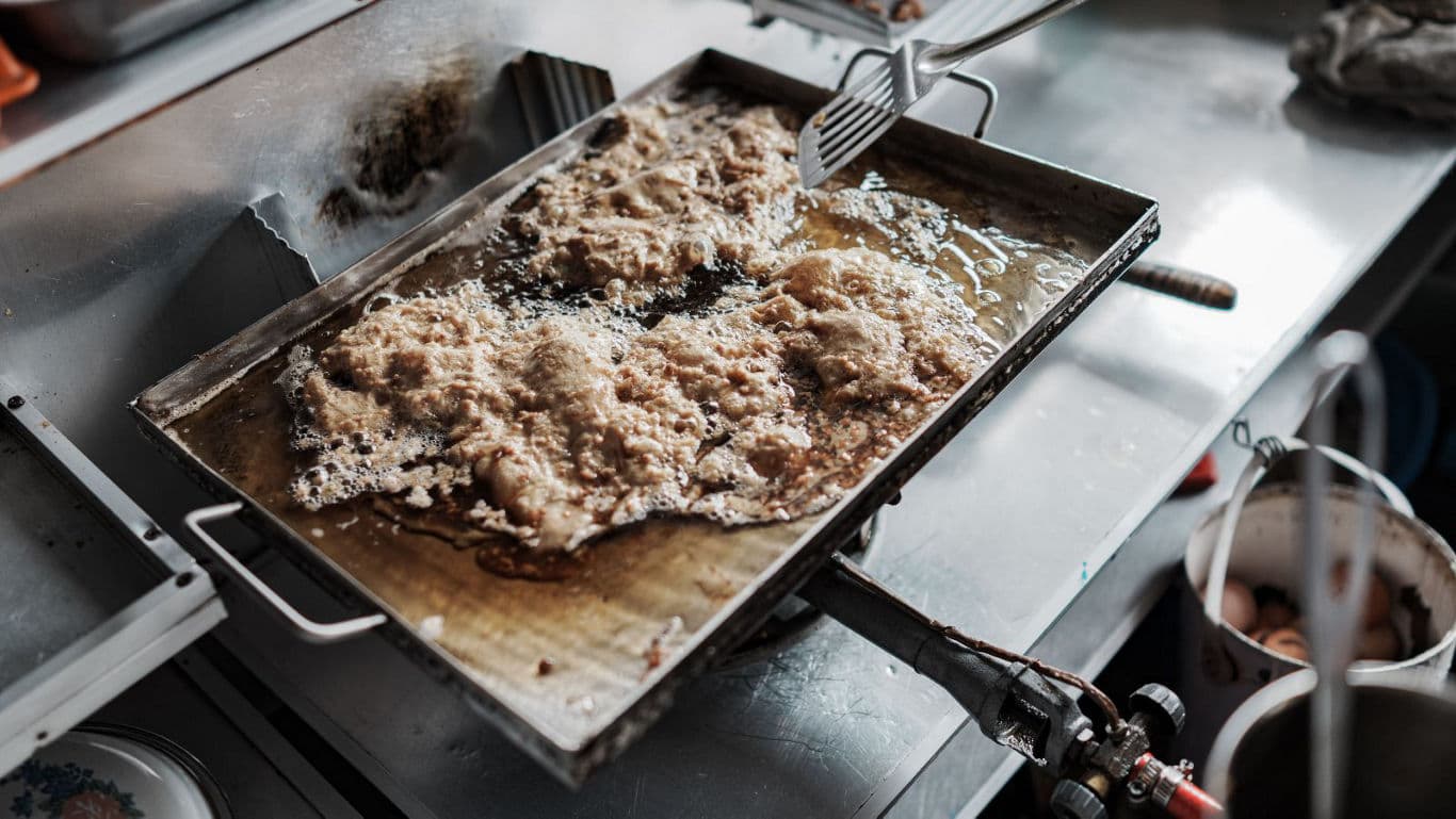 Battered food frying on commercial griddle