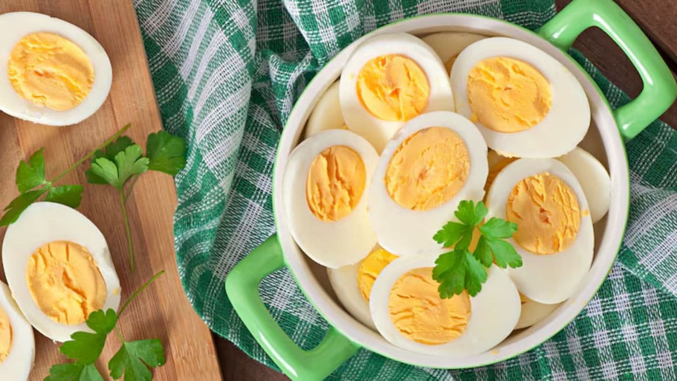 Sliced hard-boiled eggs in green ceramic bowl