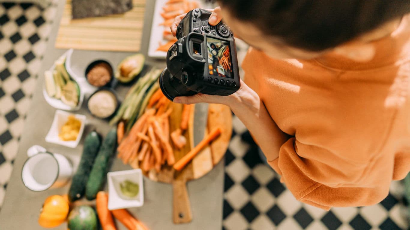 Food photographer capturing fresh vegetable spread