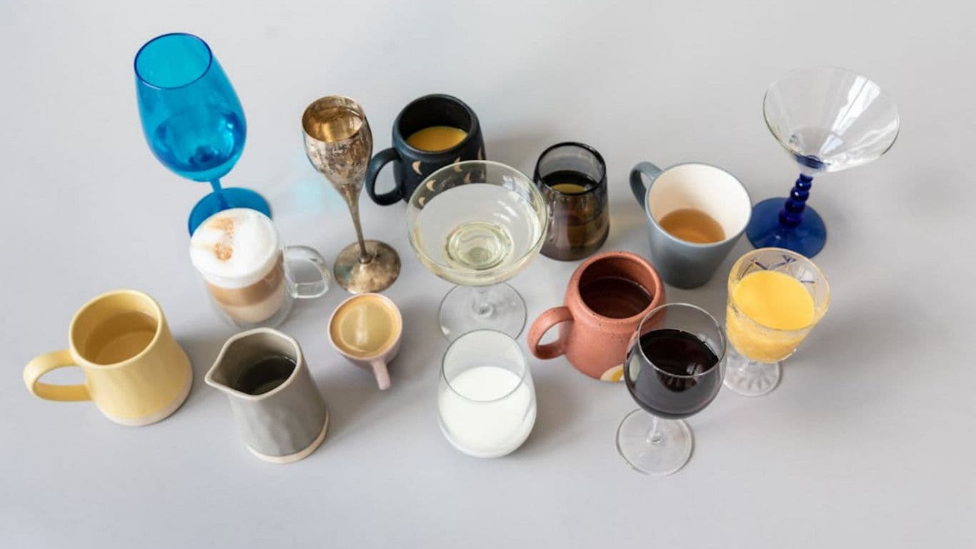 Assorted colorful cups and glasses with drinks