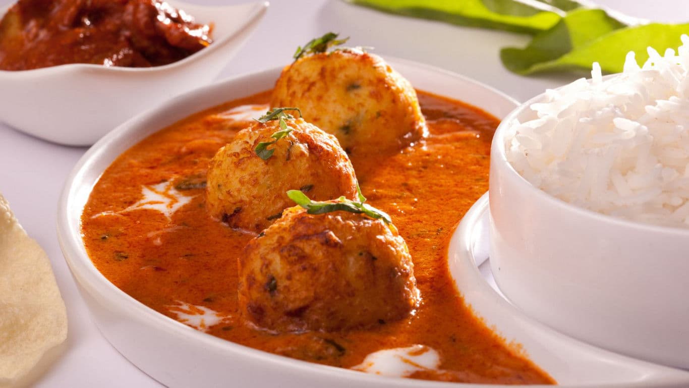 Indian curry with rice and side dishes served