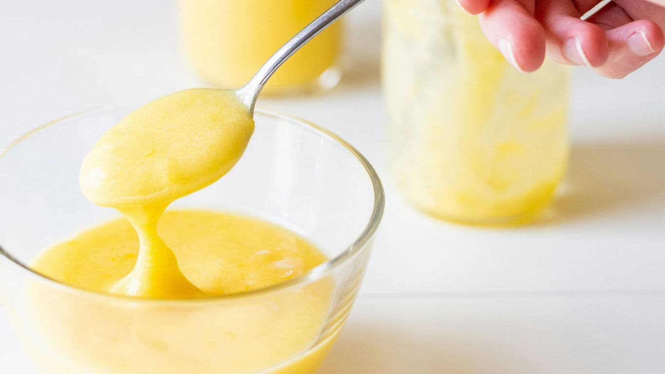 Spoonful of Homemade Lemon Curd in Glass Bowl