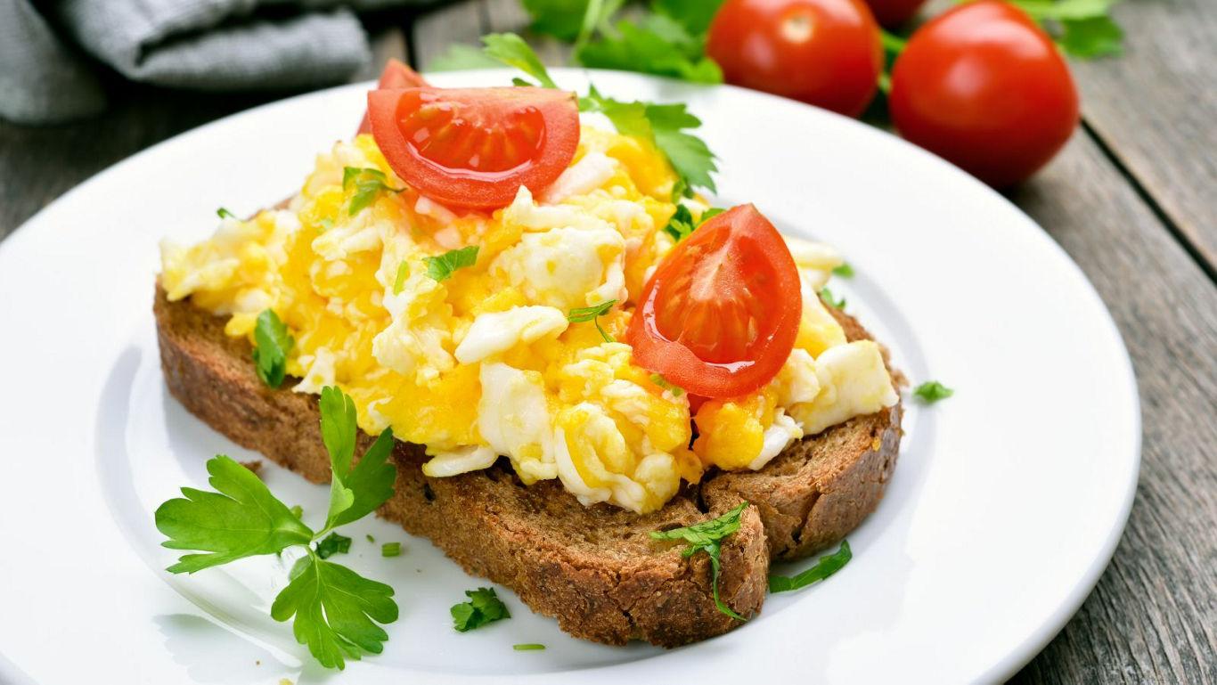 Scrambled eggs on toast with tomatoes
