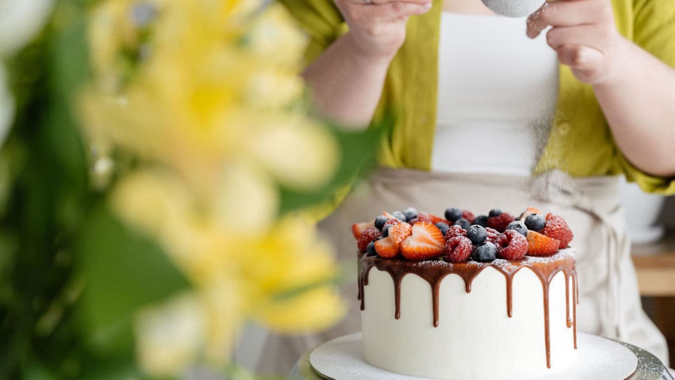 Baker Decorating Dripped Chocolate Berry Cake