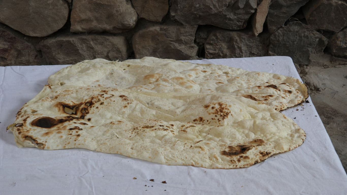 Flatbread on white cloth against stone wall