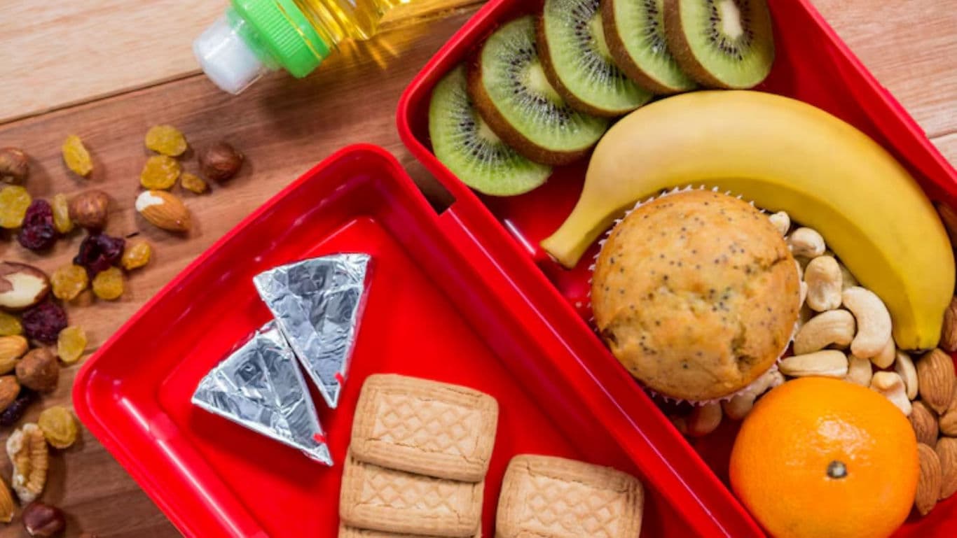 Healthy lunchbox with fruit, snacks, and biscuits