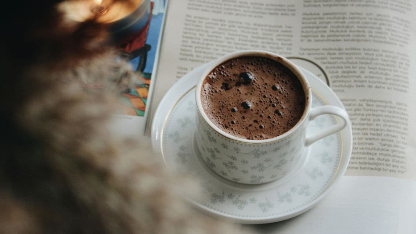 Cup of hot chocolate on open book