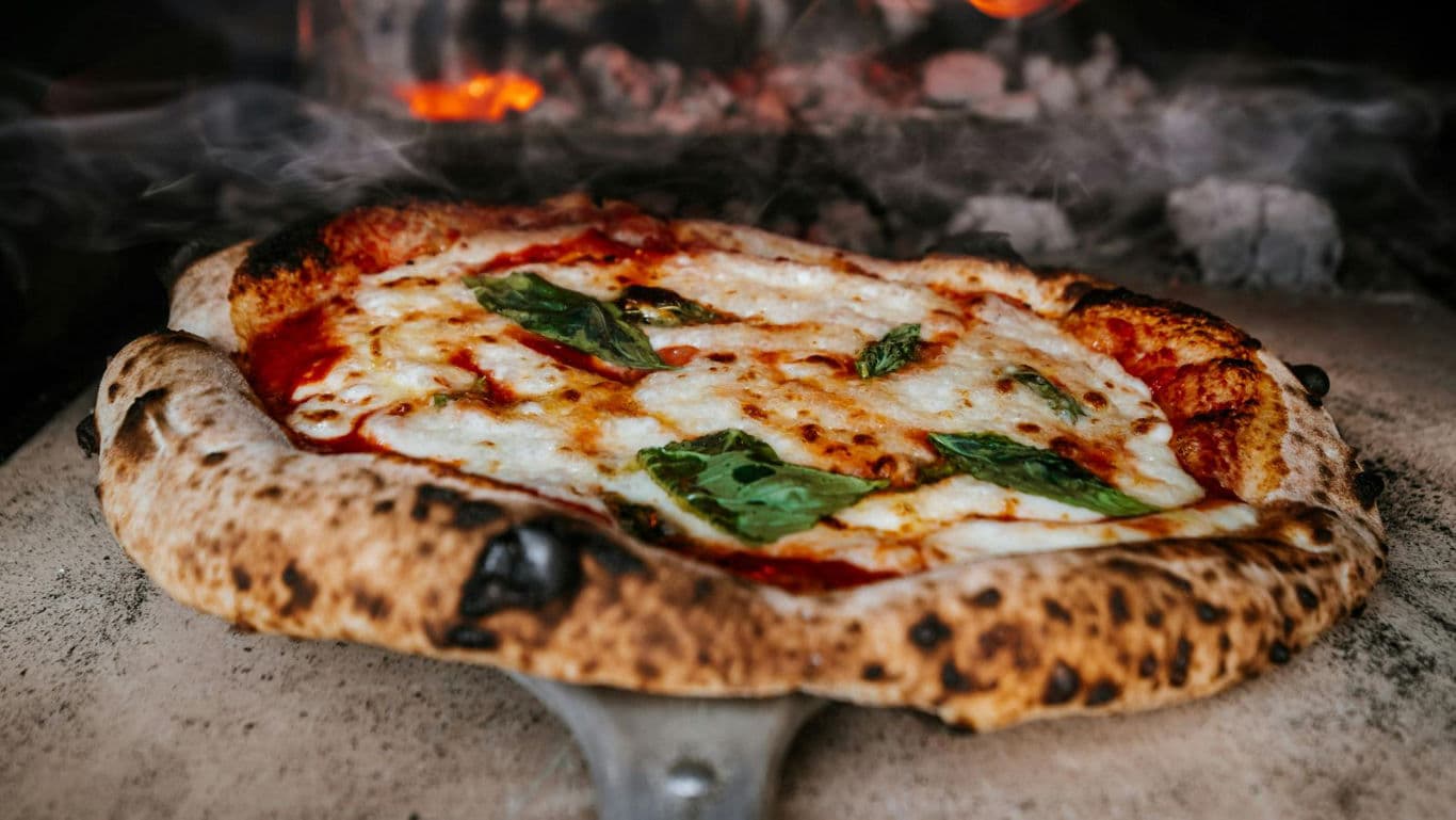Wood-fired margherita pizza in rustic oven