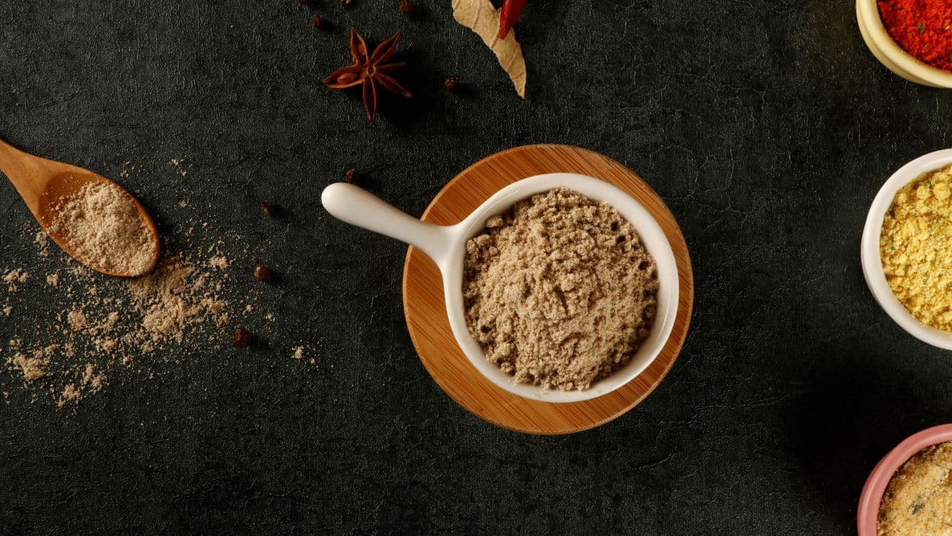 Assorted ground spices on dark stone surface