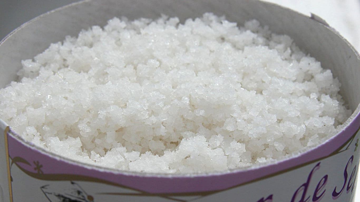 Coarse white salt crystals in round container