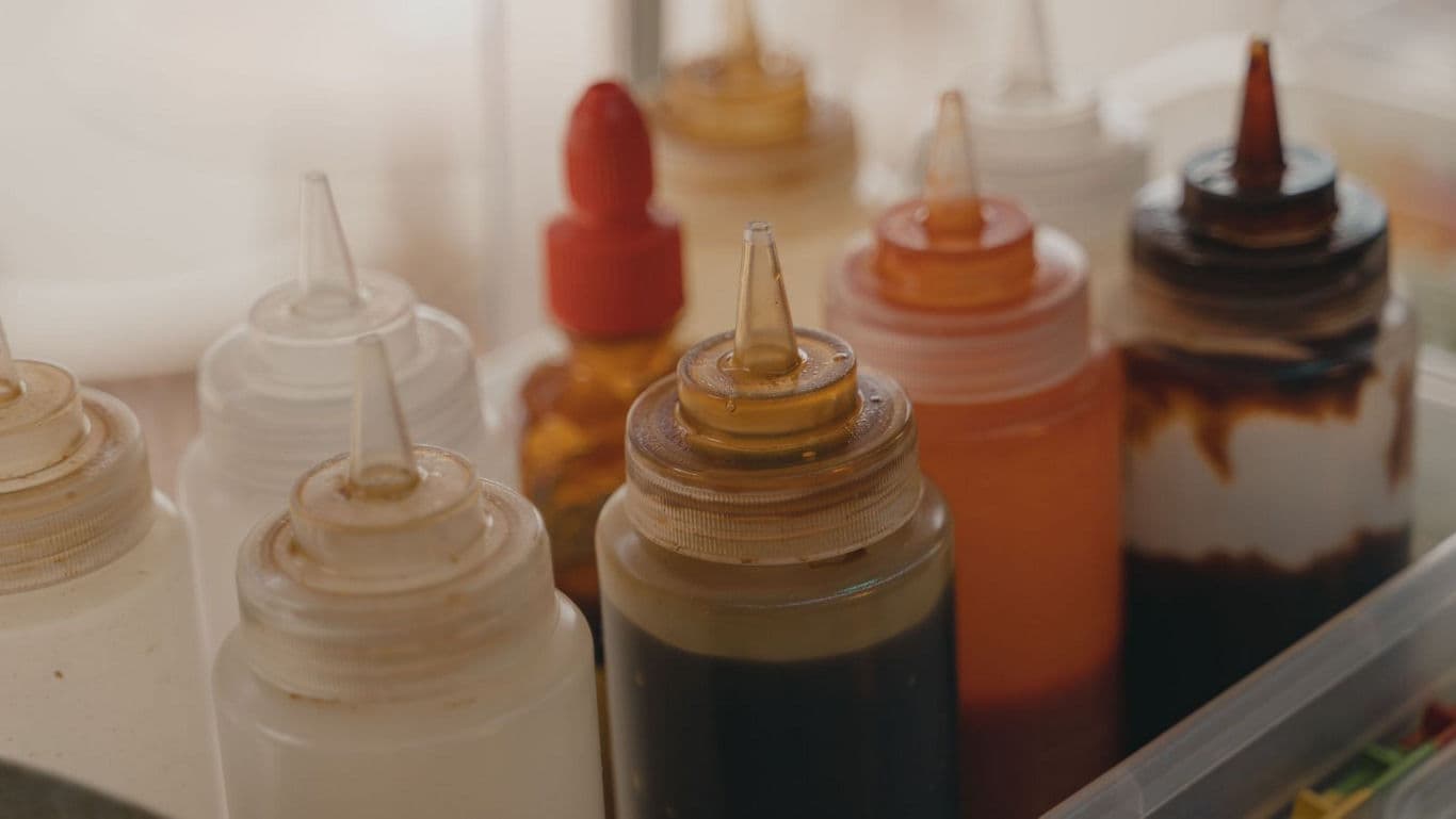 Assorted condiment squeeze bottles in kitchen