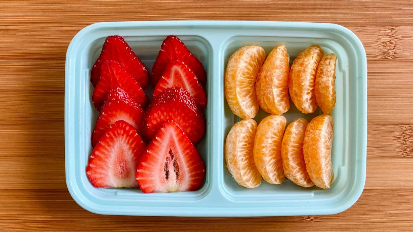 Strawberries and orange slices in bento container