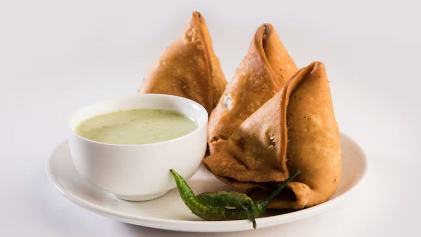 Crispy samosas served with green chutney