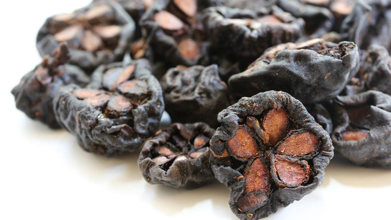 Dried black fruit with seed patterns
