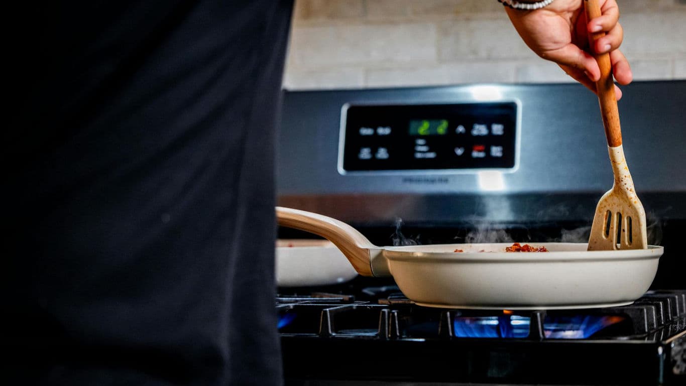Person cooking on gas stove at home