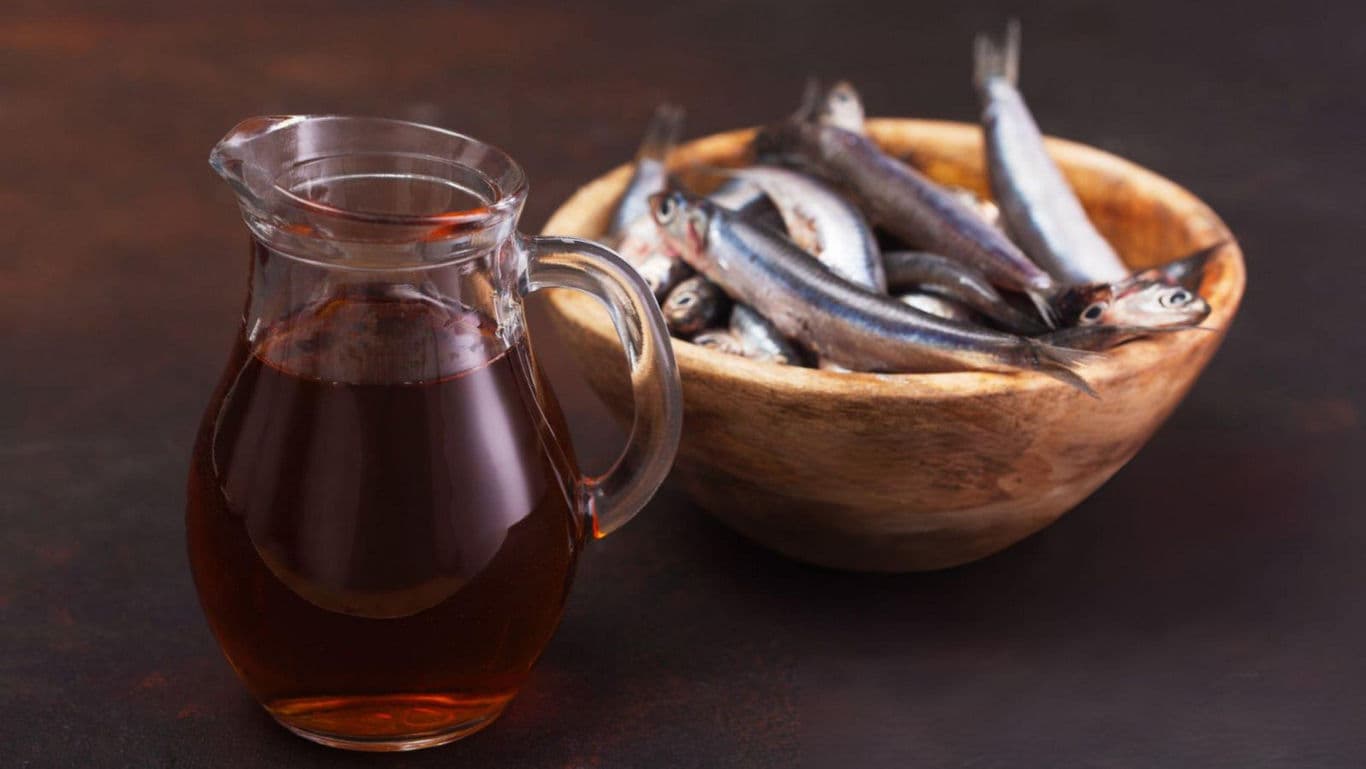 Glass pitcher with fish in wooden bowl