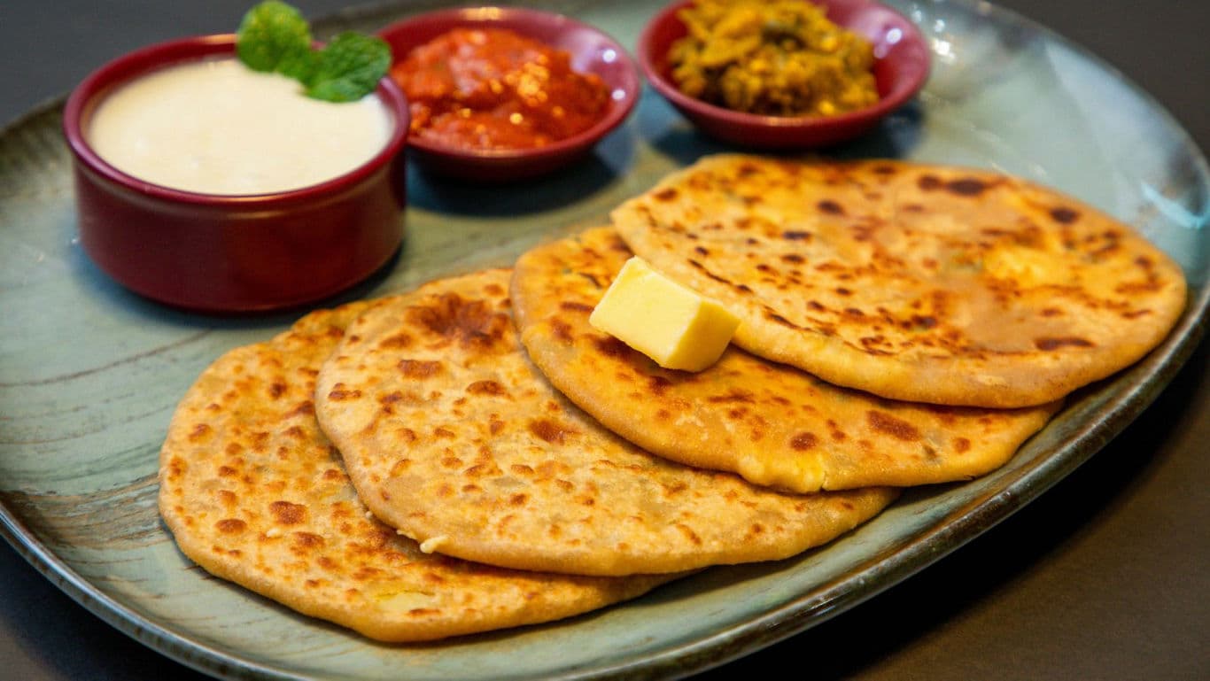 Indian stuffed paratha with butter and side dishes