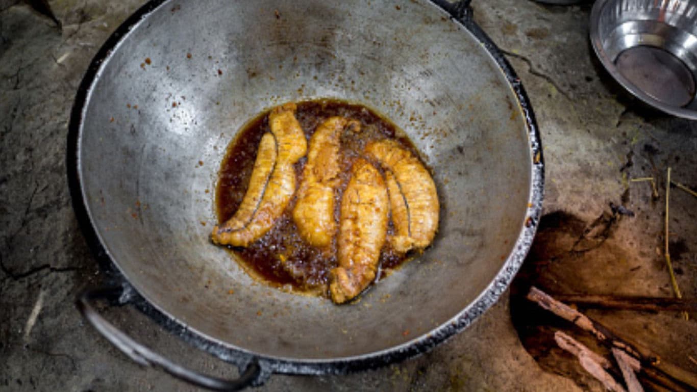 Bananas frying in rustic outdoor wok