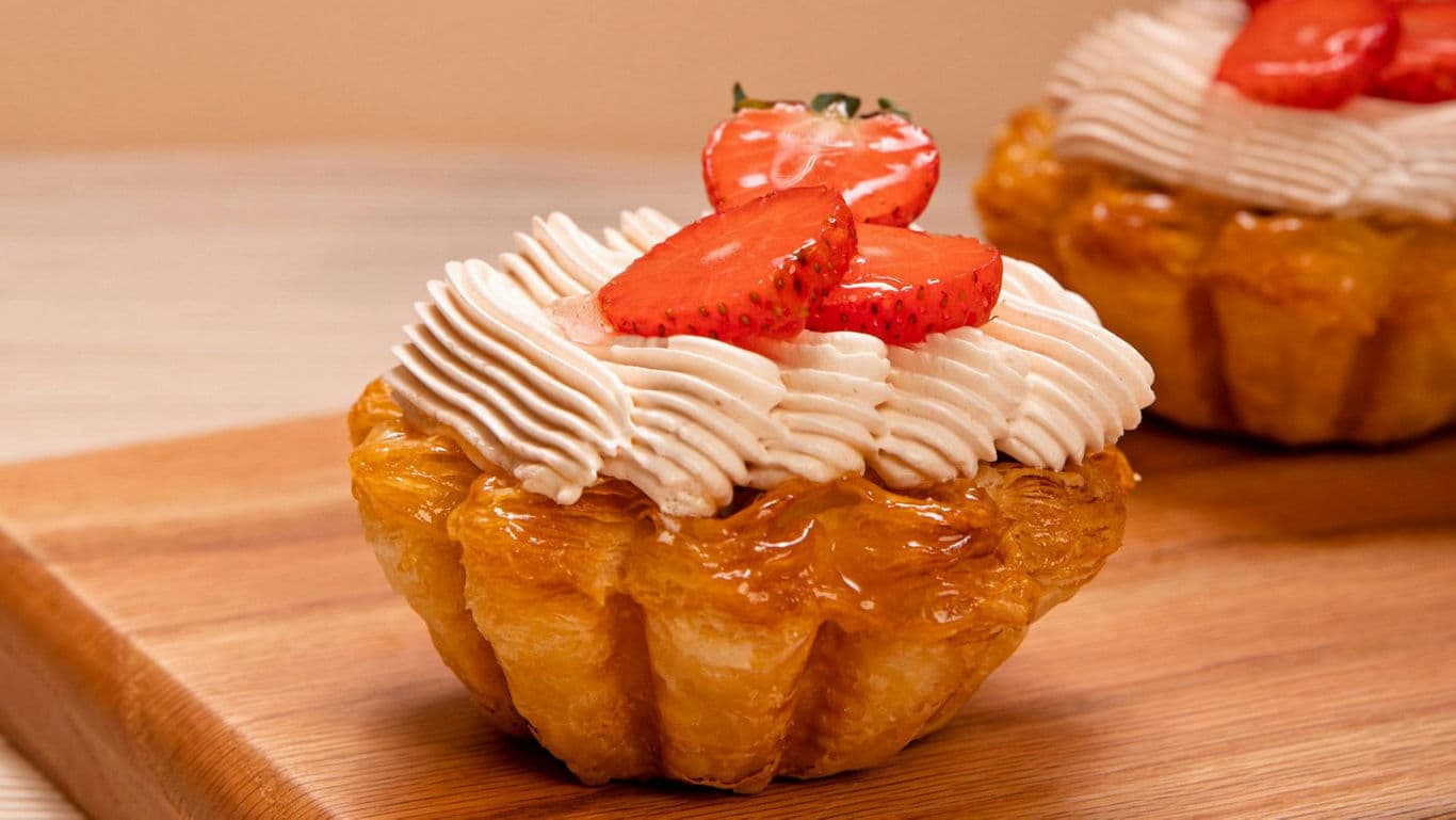 Strawberry cream tart on wooden board close-up